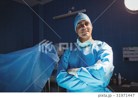 Surgeon standing with arms crossed in operation room 31971447