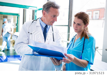 Doctor and nurse checking medical report Doctor and nurse checking medical report 31971523
