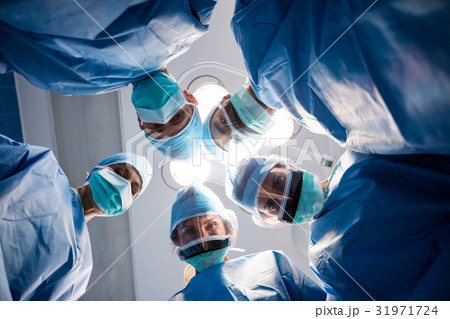 Group of surgeons looking at camera in operation room 31971724