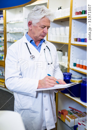 Pharmacist writing on clipboard 31971807