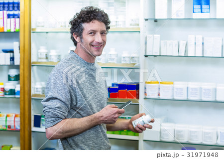 Customer using mobile phone with a bottle of drug in hand Customer using mobile phone with a bottle of drug in hand 31971948