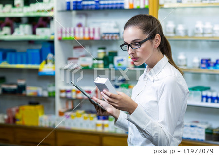 Pharmacist using digital tablet while checking medicine Pharmacist using digital tablet while checking medicine 31972079