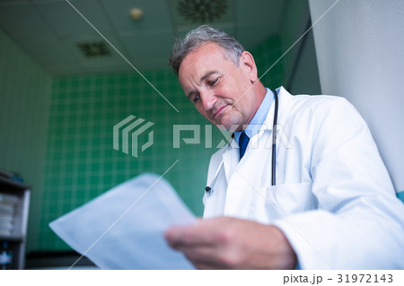 Doctor checking medical report Doctor checking medical report 31972143