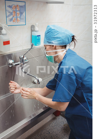 Female surgeon washing her hands Female surgeon washing her hands 31972313