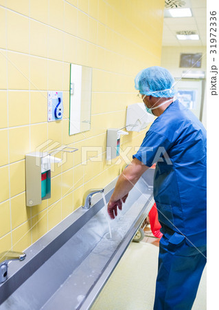 Surgeon washing their hands at washbasin Surgeon washing their hands at washbasin 31972336