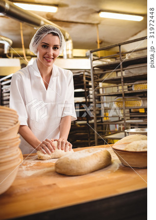 Female baker kneading a dough 31972448
