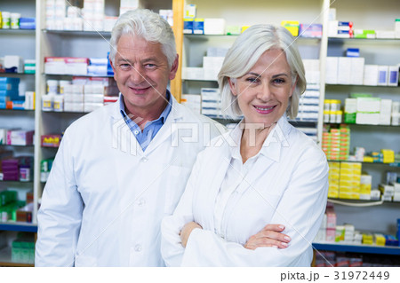 Smiling pharmacists standing in pharmacy Smiling pharmacists standing in pharmacy 31972449