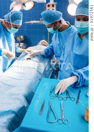 Surgeons performing operation in operation room 31972561
