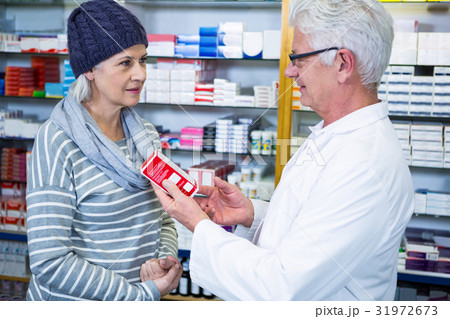 Pharmacist showing medicine to customer Pharmacist showing medicine to customer 31972673
