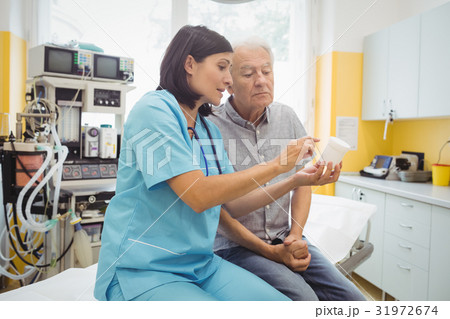 Doctor explaining medicine to his patient Doctor explaining medicine to his patient 31972674