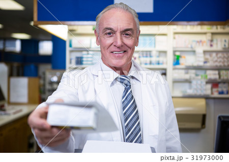 Pharmacist holding a medicine box Pharmacist holding a medicine box 31973000