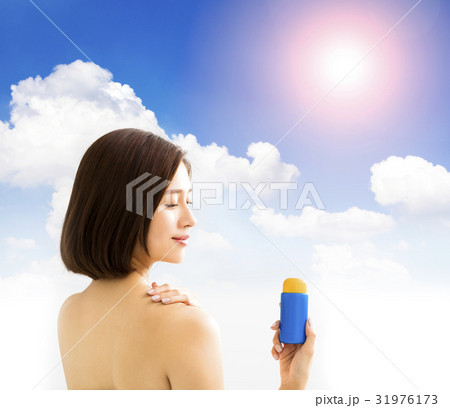 young woman showing sun protection lotion young woman showing sun protection lotion 31976173
