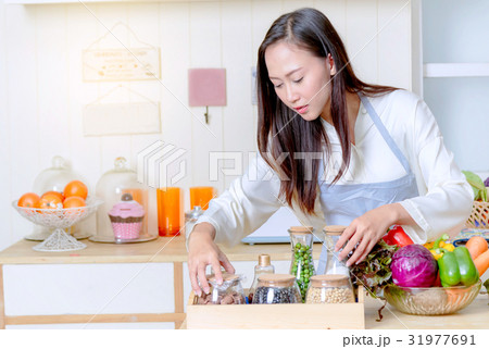 woman in an apron cooking food in the kitchen woman in an apron cooking food in the kitchen 31977691