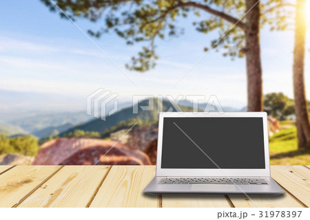 Laptop with blank screen on wooden table Laptop with blank screen on wooden table 31978397