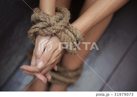 woman was tormented the the hands tied with a rope 31979073