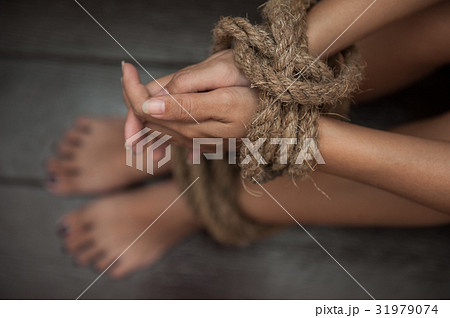 woman was tormented the the hands tied with a rope 31979074