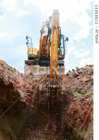 Excavator digging a pit.  31983633