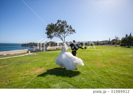 Couple smiling and embracing near wedding arch on 31989912