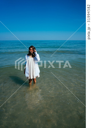 The girl is standing in the sea by the shore The girl is standing in the sea by the shore 31994582