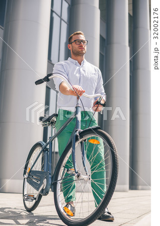 Cool young bearded hipster with bicycle on the Cool young bearded hipster with bicycle on the 32002176