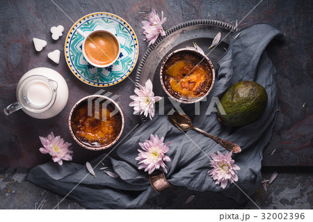 Still life with creme brulee , avocado and cup of 32002396
