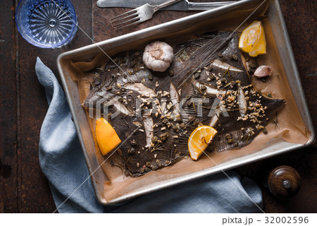 Baking tray with flounder and seasoning on the 32002596