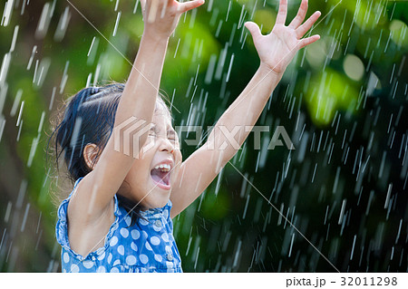 Happy asian girl having fun to play with rain Happy asian girl having fun to play with rain 32011298