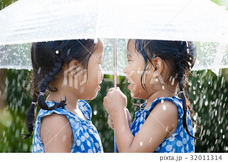 two asian girls with umbrella play with the rain 32011314