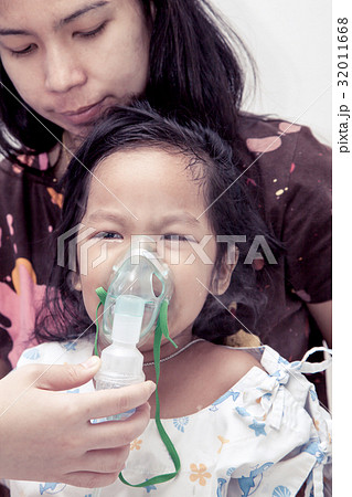 little girl crying while getting in inhaler mask 32011668