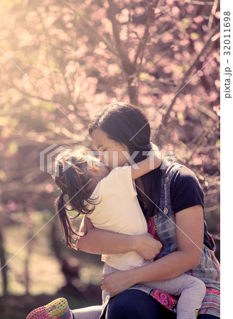 Mother kiss and hug daughter in the park 32011698