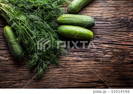 Cucumber and dill on very old rustic oak table. Cucumber and dill on very old rustic oak table. 32014598