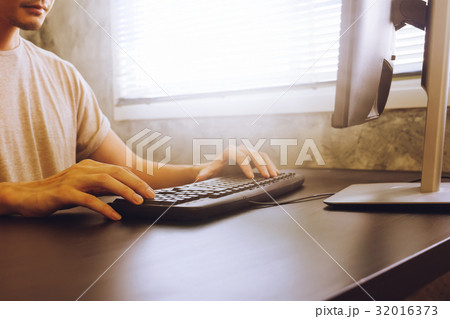 Casual young man working on computer 32016373