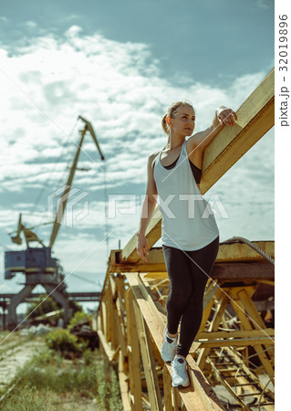 Beautiful woman in sports uniform posing against Beautiful woman in sports uniform posing against 32019896