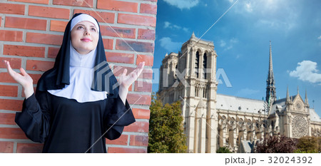 Young smiling nun standing near brick wall 32024392