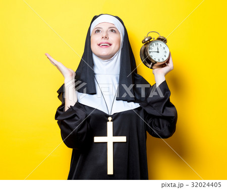 Young happy nun with alarm clock 32024405