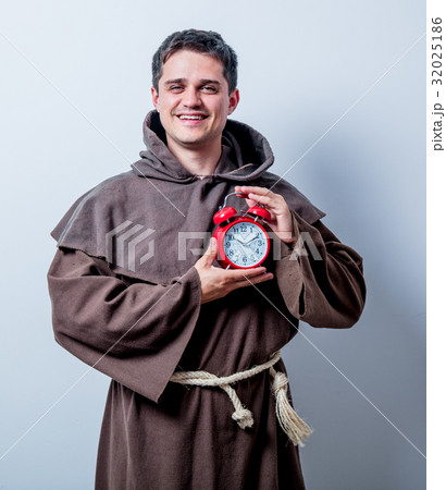 Portrait of Young catholic monk with alarm clock 32025186
