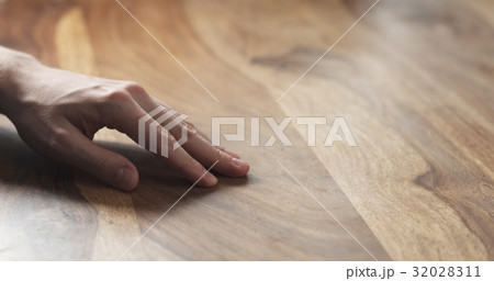 closeup of man hand checking hard wood surface 32028311