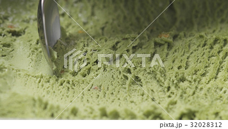 macro of pistachio ice cream being scooped with 32028312