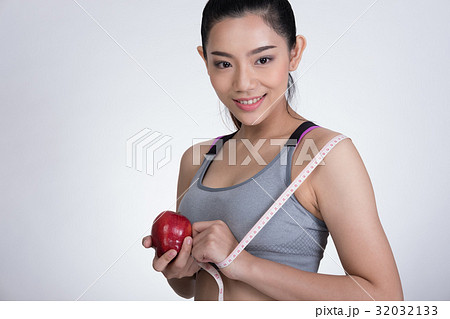 sporty fitness woman with measuring tape and red apple standing against white background. diet, sport and health concept 32032133