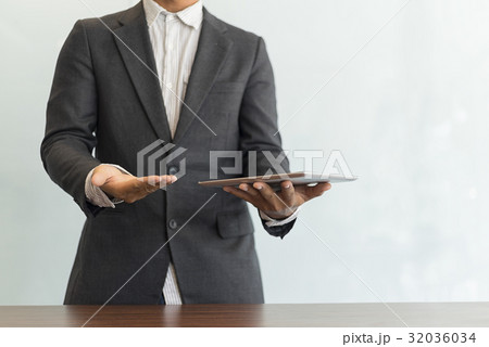 Businessman using his tablet in the office 32036034