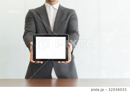 Businessman using his tablet in the office 32036035