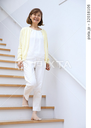 階段を降りるシニア女性の写真素材
