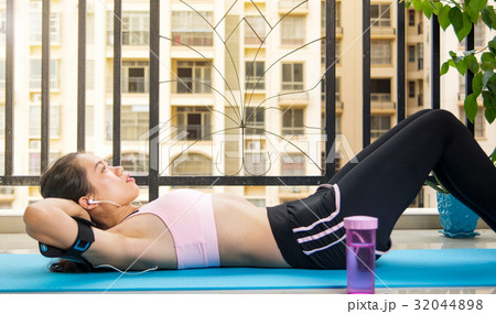 Girl doing crunches on the balcony Girl doing crunches on the balcony 32044898