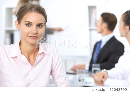 Portrait of a young business woman against a group Portrait of a young business woman against a group 32048709