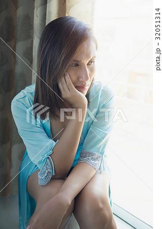 Asia people mournfully looks out her window 32051314