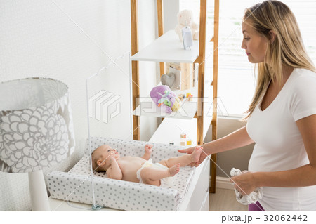 Mother changing the diaper of her baby 32062442