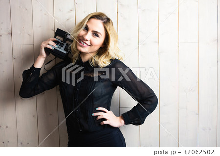 Beautiful woman posing with camera against texture background 32062502