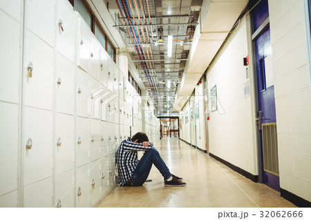 Depressed student sitting in locker room 32062666