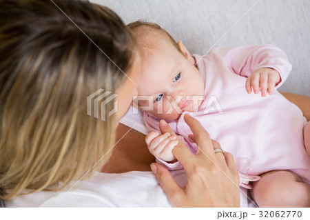 Mother playing with her baby in bedroom 32062770