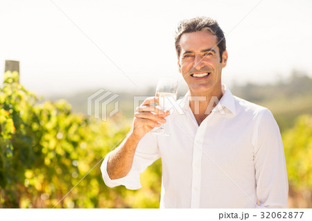 Portrait of smiling male vintner holding a glass of wine 32062877